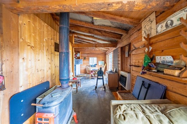 Miscellaneous room with wood walls, heating unit, a wood stove, and vaulted ceiling | Image 23