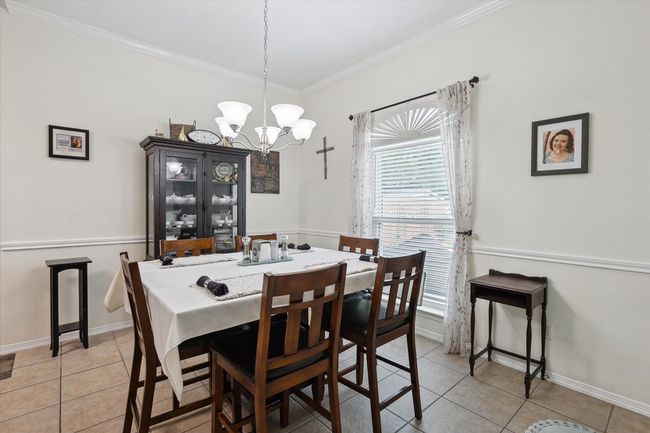 Dining area with crown molding, and decorative light. | Image 12