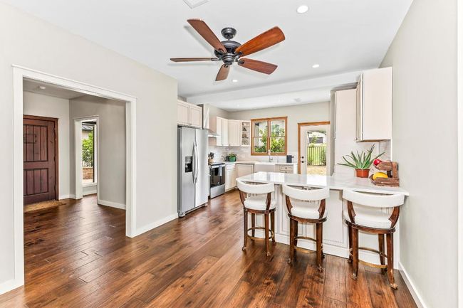 Kitchen with stainless steel appliances, a peninsula, light countertops, plenty of natural light, and recessed lighting | Image 7