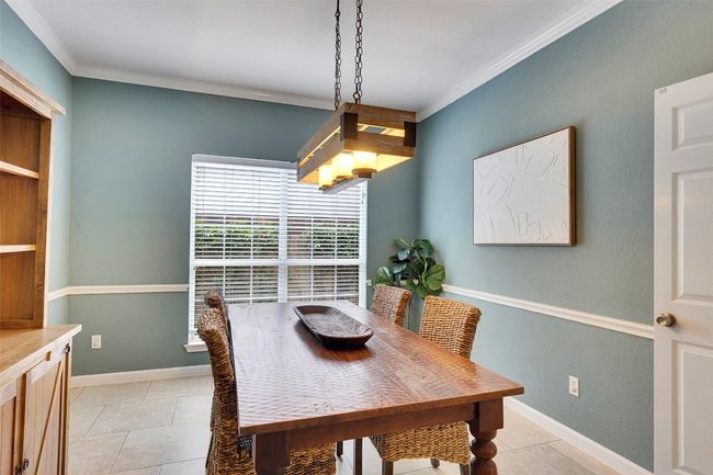 Dining space featuring light tile patterned floors, crown molding, and baseboards | Image 17