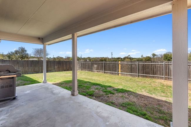 Spacious back patio with outdoor seating/grilling area and a fully-fenced backyard | Image 34