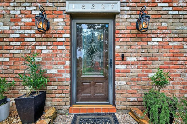 Nestled behind a storm door and flanked by vintage-style sconces, the front door opens with subtle charm. It sets the tone for the home’s thoughtful balance of function and grace. | Image 7