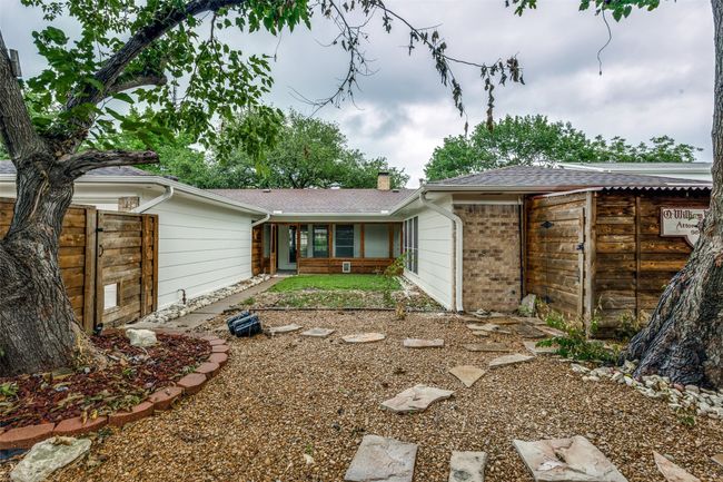 Rear view of property featuring a chimney, brick siding, and roof with shingles | Image 25