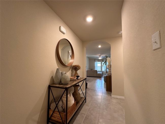Hallway featuring tile patterned flooring, arched walkways, a textured wall, baseboards, and recessed lighting | Image 14