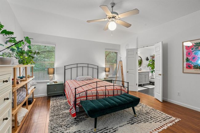 Bedroom with vaulted ceiling, wood finished floors, ensuite bath, and a ceiling fan | Image 18