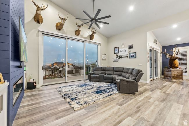 Living area featuring recessed lighting, wood finished floors, a fireplace, a ceiling fan, and lofted ceiling | Image 78
