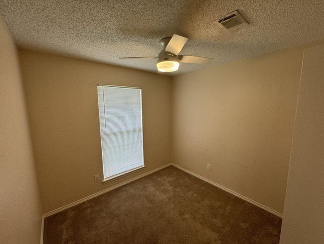 Unfurnished bedroom with dark colored carpet, a closet, ceiling fan, and a textured ceiling | Image 24