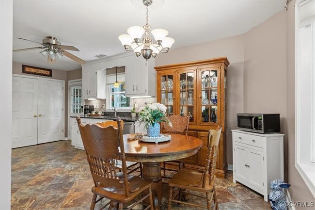 Dining room featuring stone finish floors, a chandelier, and ceiling fan | Image 19