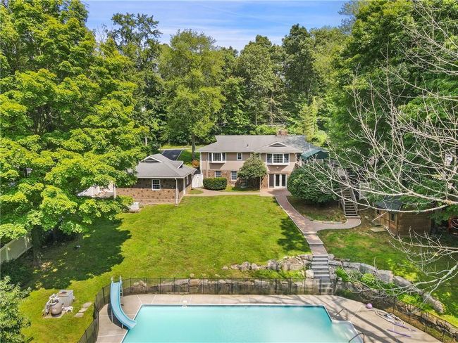 View of swimming pool featuring a water slide and a yard | Image 31