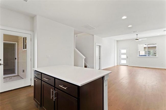 Kitchen featuring wood finished floors, light countertops, ceiling fan, dark brown cabinetry, and recessed lighting | Image 7