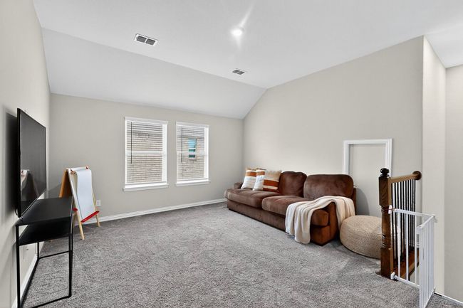Carpeted game room with lofted ceiling and baseboards | Image 21