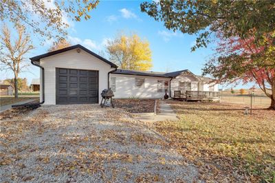 Single story home with a wooden deck and a garage | Image 1