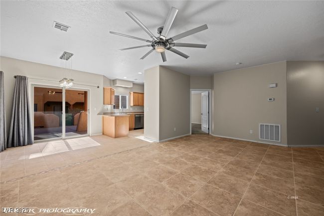 Unfurnished living room with baseboards, visible vents, a sink, and a ceiling fan | Image 5