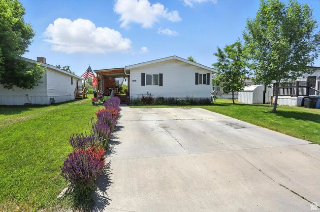 Manufactured / mobile home featuring a storage shed, a front yard, and driveway | Image 25