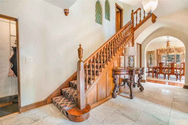 Staircase in the entrance that leads to the second floor. The door at the midpoint leads to the kitchen on the first floor. | Image 11