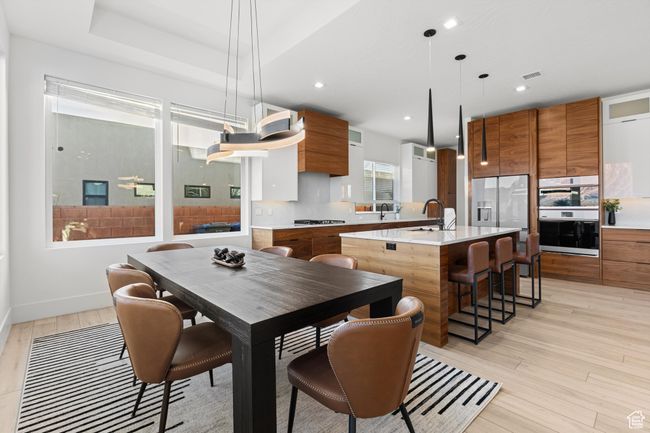 Dining space featuring visible vents, baseboards, light wood finished floors, and recessed lighting | Image 9
