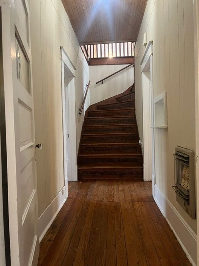 Staircase featuring hardwood / wood-style flooring, heating unit, and wooden walls | Image 16