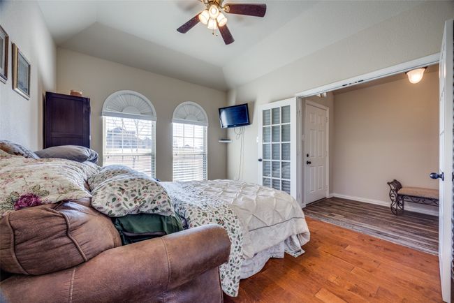 Bedroom with hardwood / wood-style floors, vaulted ceiling, and ceiling fan | Image 12