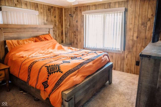 carpeted bedroom featuring wooden walls | Image 25