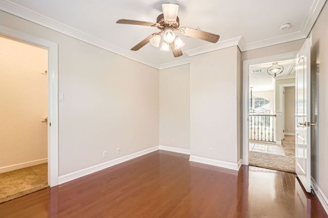Spare room featuring crown molding, baseboards, a ceiling fan, and wood finished floors | Image 33