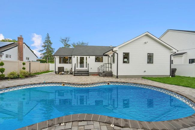 View of swimming pool with a fenced backyard | Image 33