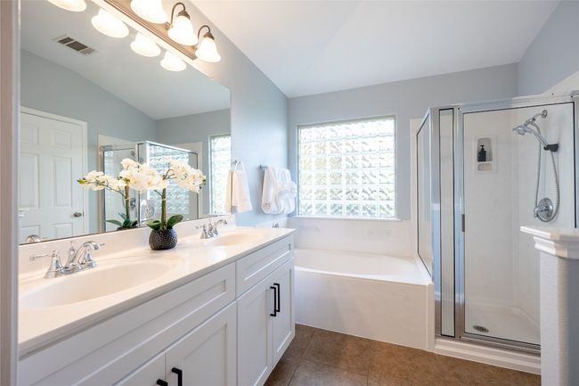 Bathroom with a shower stall, a garden tub, double vanity, tile patterned flooring, and vaulted ceiling | Image 14