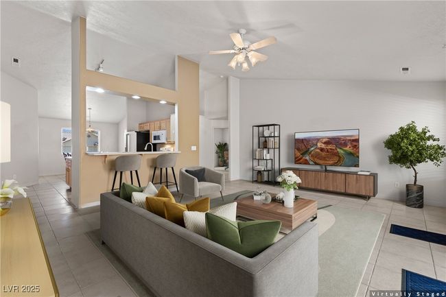 Living room with light tile patterned floors, ceiling fan, and vaulted ceiling | Image 12