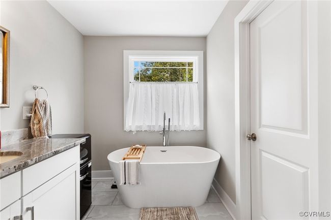 Full bath with baseboards, a freestanding tub, marble finish floor, and vanity | Image 32