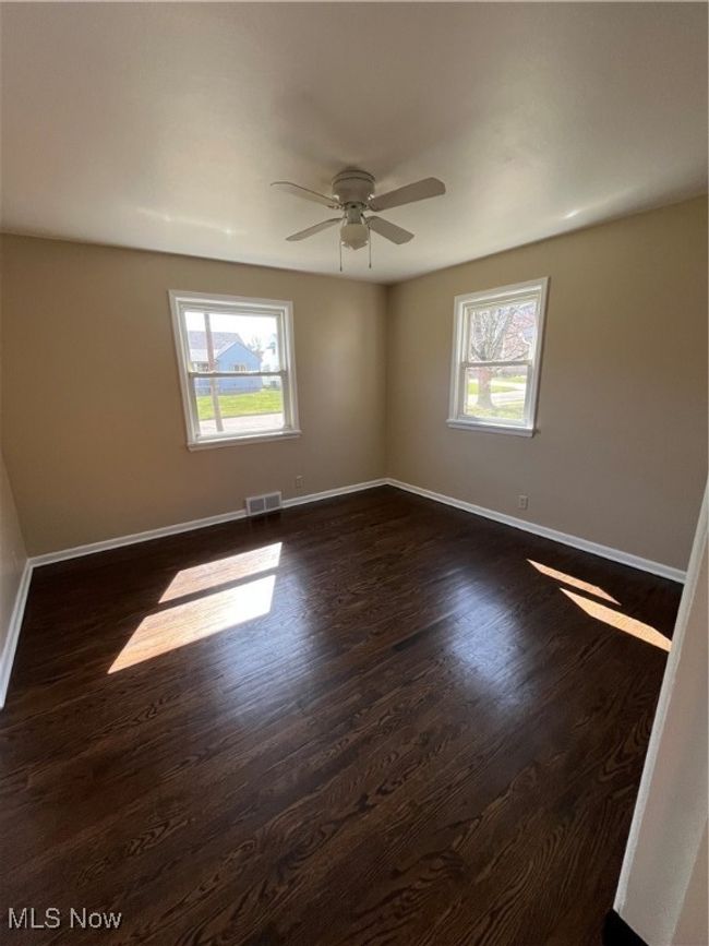 Bedroom featuring ceiling fan, plenty of natural light, and beautiful floors. | Image 21