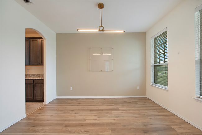 Unfurnished dining area featuring light wood-style floors and arched walkways | Image 4
