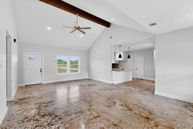 Unfurnished living room featuring high vaulted ceiling, beam ceiling, a ceiling fan, recessed lighting, and concrete floors | Image 17