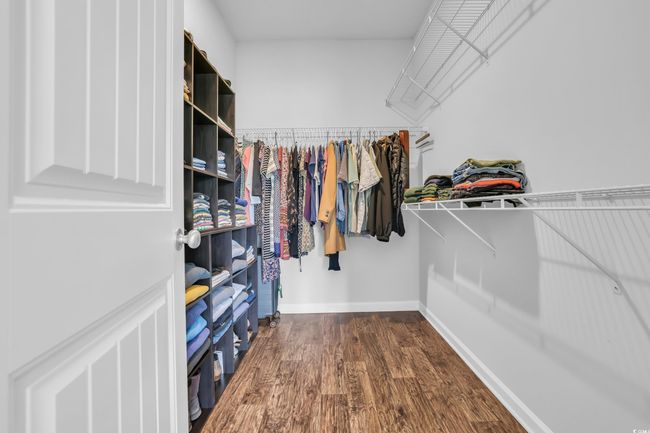 Spacious closet featuring dark wood-style flooring | Image 30