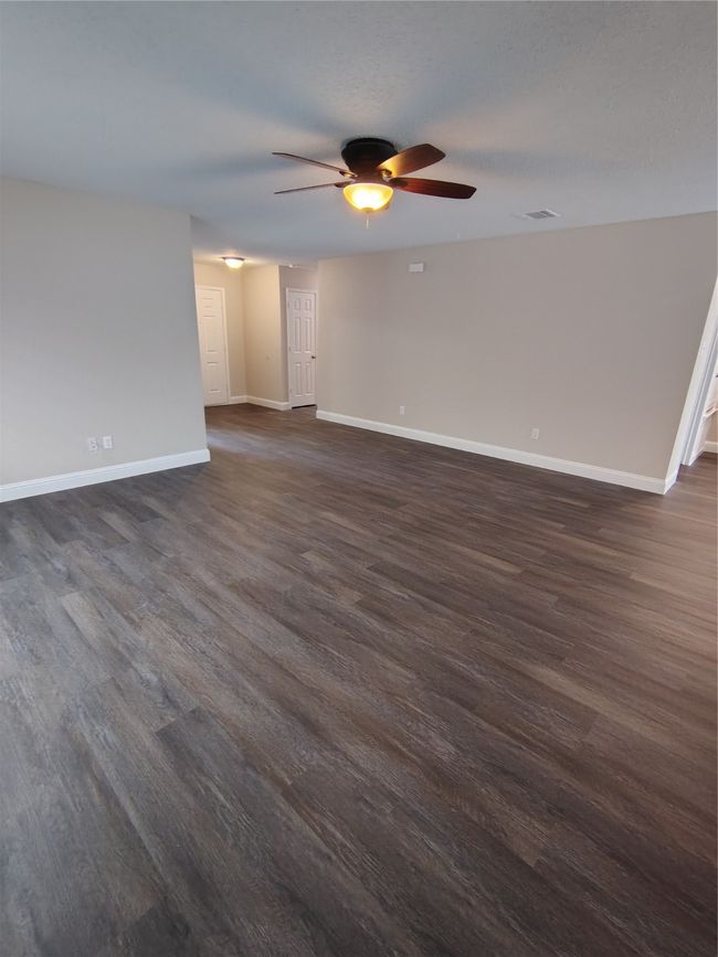 Unfurnished room featuring ceiling fan, dark wood finished floors, and baseboards | Image 16