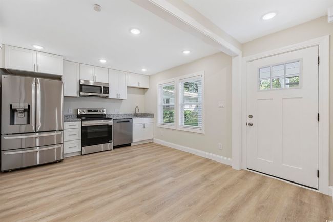 Kitchen featuring stainless steel appliances, white cabinetry, light wood-style floors, recessed lighting, and baseboards | Image 24