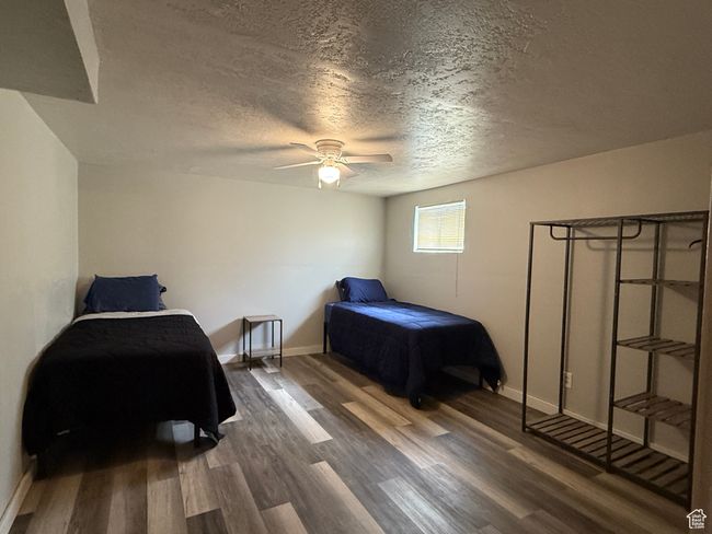 Bedroom featuring a textured ceiling, wood finished floors, baseboards, and a ceiling fan | Image 13