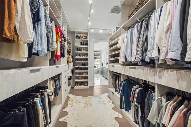 [Primary Dressing Room] Alternate view of this large closet.... notice the great shoe rack cabinet, plus additional shelving and hanging space behind the door! | Image 26