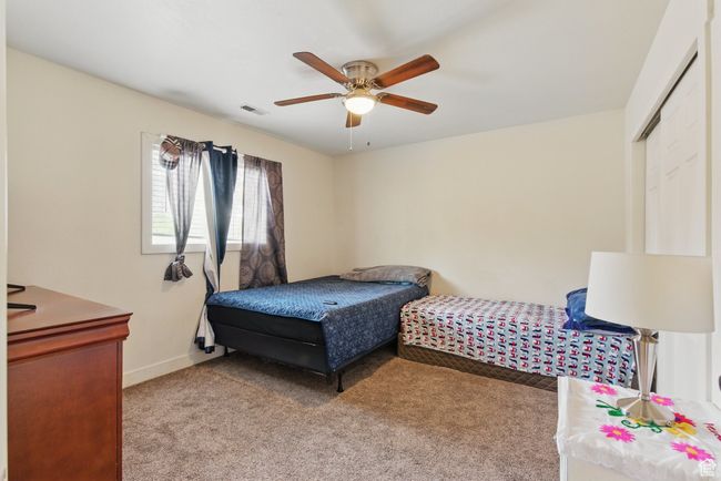 Bedroom featuring light carpet, a ceiling fan, visible vents, and baseboards | Image 22