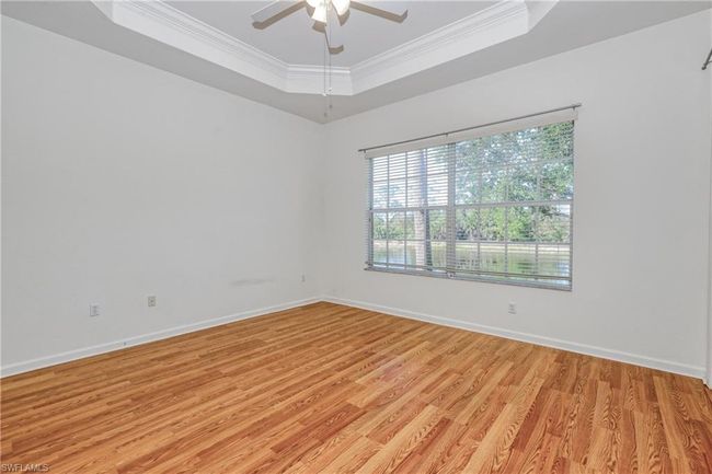 Spare room featuring a raised ceiling, crown molding, and light hardwood / wood-style flooring | Image 32