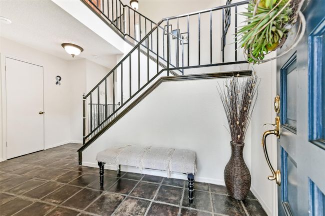 Bright foyer with tiled flooring, featuring a stylish staircase offering a welcoming entrance. | Image 7