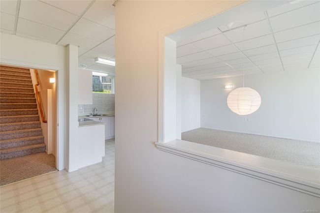 Hallway with a paneled ceiling, light floors, stairway, and a sink | Image 53
