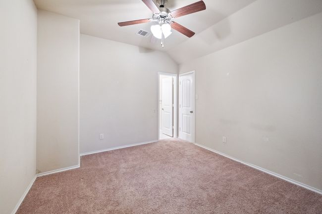 Carpeted spare room featuring a ceiling fan and lofted ceiling | Image 13