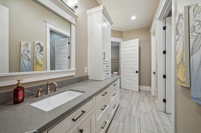 The Hollywood bathroom, conveniently located between bedrooms 2 and 3, is designed for both style and functionality. It features double sinks with custom cabinetry, a separate tub and shower combination with custom tilework, and is thoughtfully designed to be wheelchair accessible, ensuring comfort and ease for all. | Image 23