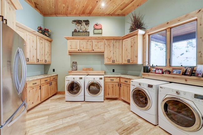 The main laundry room has space for two sets of washers and dryers, a secondary refrigerator, and a sink. | Image 28