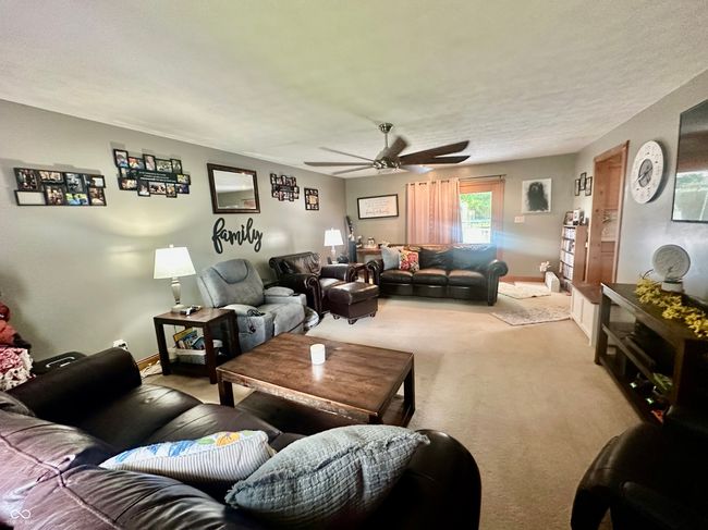 carpeted living area with ceiling fan | Image 24