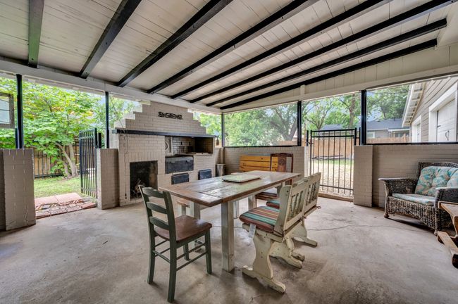 Sunroom / solarium featuring a brick fireplace and outdoor dining space | Image 22