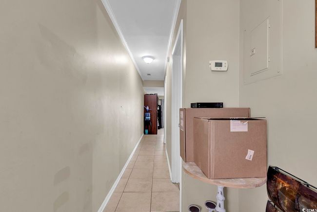 Hall featuring light tile patterned floors, baseboards, and electric panel | Image 16