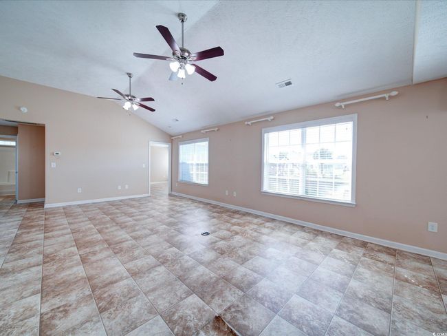 Unfurnished room featuring ceiling fan and vaulted ceiling | Image 11