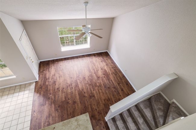 Unfurnished dining area with stairs, ceiling fan, baseboards, and wood finished floors | Image 6