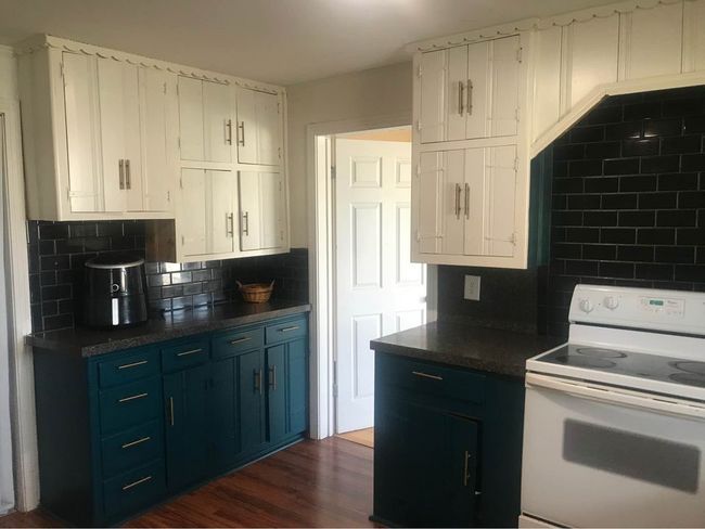 Kitchen featuring tasteful backsplash, white cabinets, blue cabinets, white range with electric stovetop, and dark countertops | Image 6