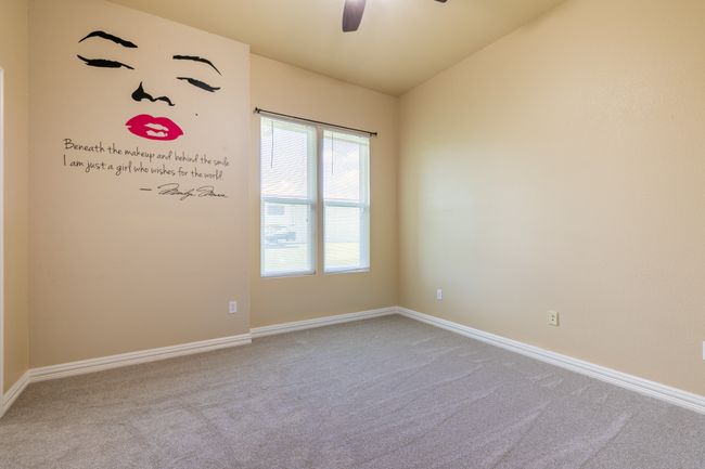 Carpeted empty room featuring a ceiling fan and vaulted ceiling | Image 13
